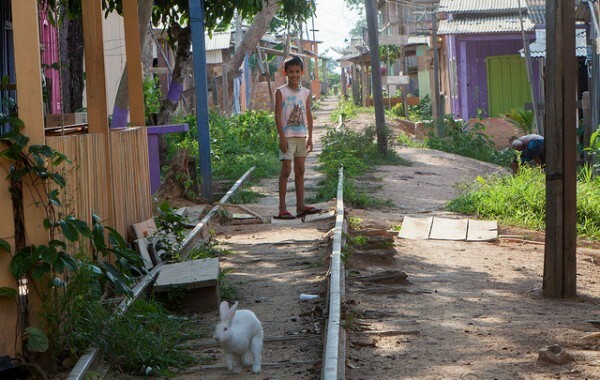 Menino entre casa de ribeirinhos e o trilho da antiga estrada de ferro Madeira Mamoré. Foto: Marcelo Min/Agência Pública