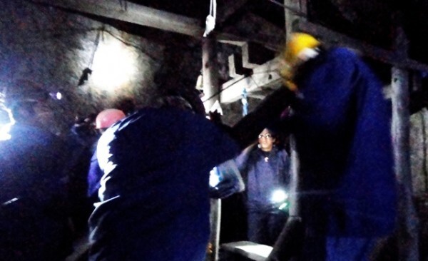 Dentro de uma mina, o cheiro forte de minério e o ar rarefeito se sobressaem. Na foto, turistas observam mineiros retirarem bolsas de minério de um andar inferior (Foto: Jessica Mota)